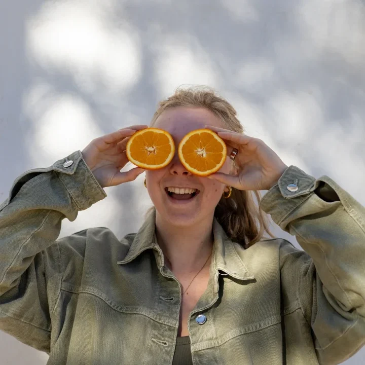 Blije vrouwencoach met fruit voor hormoonbalans